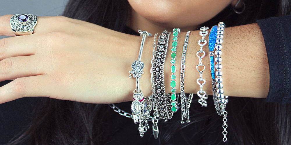 Braço em foco, vestindo belíssimas pulseiras de prata.